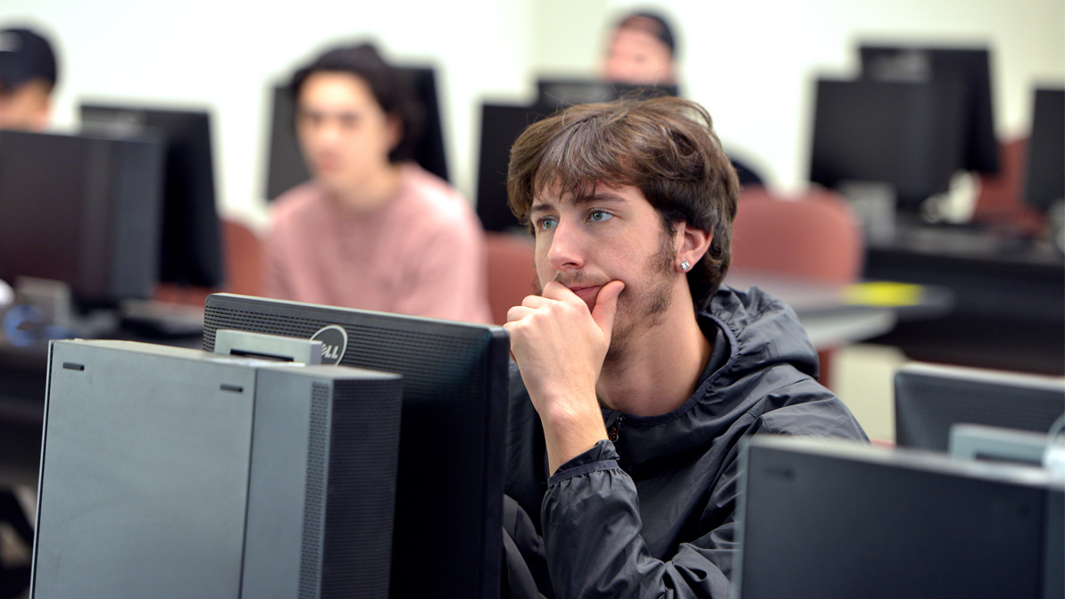 A male student working in a computer lab